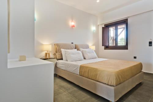una camera con un grande letto e una finestra di Michaliou Kipos Luxury Villas ad Afiartis