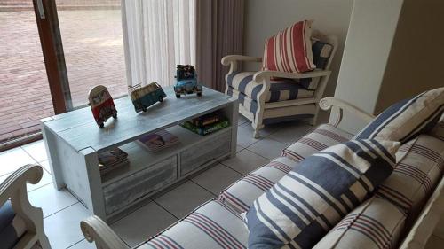 a living room with a couch and a table at Mafari Beach House in Hermanus