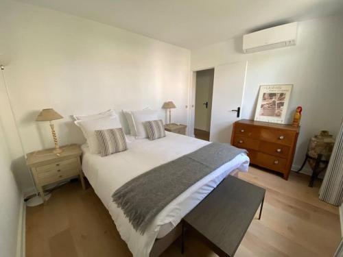 - une chambre avec un grand lit blanc et une table de nuit dans l'établissement Appartement Saint Antoine - Centre Ville, à Saint-Tropez