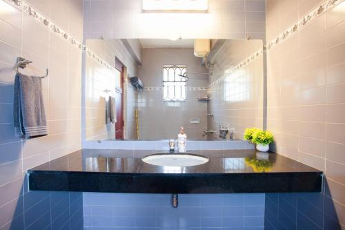 uma casa de banho com um lavatório e um espelho em 'Golden Coral' 2bhk Benaulim Beach villa Goa em Margão