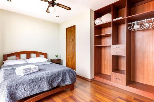 1 dormitorio con cama y armario en Apartamentos Estela en Alameda colonial - 5km Aeropuerto Jorge Chávez en Lima