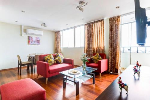 sala de estar con muebles de color rojo y mesa en Apartamentos Estela en Alameda colonial - 5km Aeropuerto Jorge Chávez en Lima
