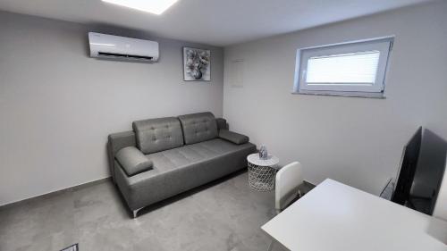 sala de estar con sofá y TV en Apartma ALTER EGO, en Koper