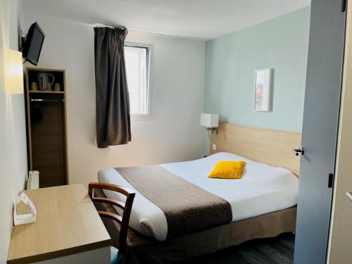 a small room with a bed and a desk and a table at The Originals City, Hotel Novella Confort, Nantes Est in Carquefou