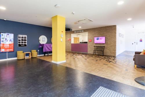 a lobby with a yellow pillar and a table at For Students Only Fresh Oldway Centre Swansea in Swansea