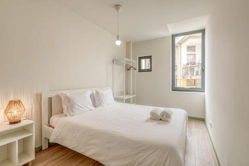 - une chambre blanche avec un lit blanc et une fenêtre dans l'établissement Travel and Live Apartments, à Porto