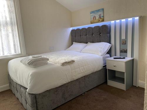 a bedroom with a large bed with a blue headboard at Sylvern House in Scarborough