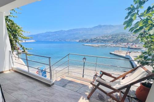 a balcony with a chair and a view of the water at House of light in Évdhilos