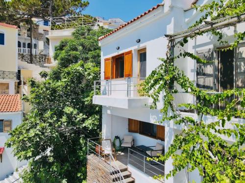 an apartment building with a balcony and trees at House of light in Évdhilos