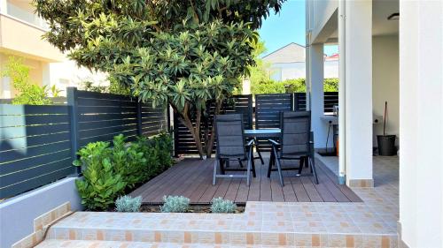 un patio con mesa y sillas bajo un árbol en Apartment Judy, Terrace&Garden, 80m from the Beach en Sveti Filip i Jakov