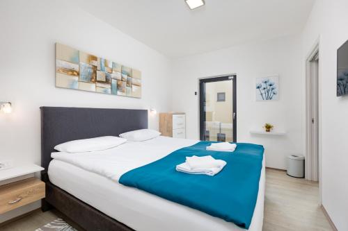 a bedroom with a large bed with a blue blanket at Ferienwohnung mit beheiztem Pool in Villa Gracia in Stara Baška