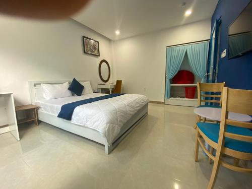 a bedroom with a bed and a table and a chair at Alicia Hotel in Tuy Hoa