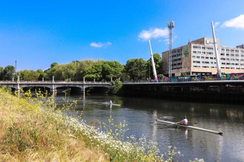 a man in a boat on a river with a bridge at Principality View Apartment Two, by Solace Stays in Cardiff