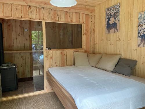 a bedroom with a bed in a wooden room at Ferienwohnung am Waldrand mit Sauna in Biendorf