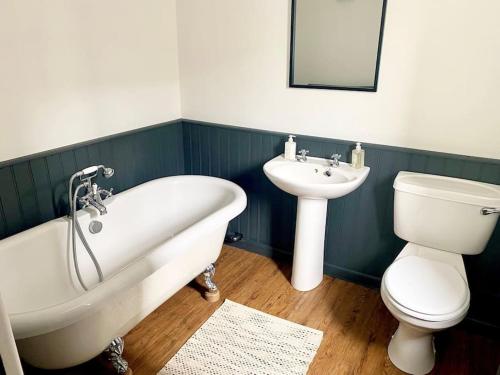 a bathroom with a tub and a toilet and a sink at Lovely 2 bedroom apartment in Much Wenlock in Much Wenlock