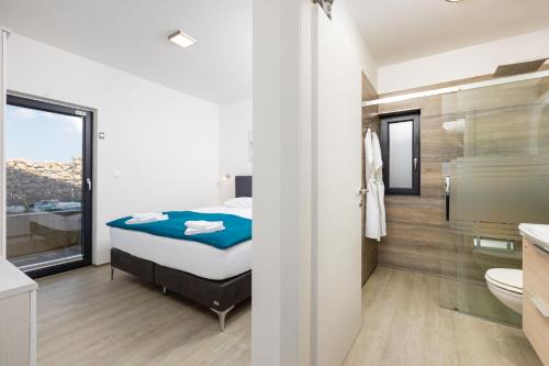 a bedroom with a bed and a bathroom at Ferienwohnung mit beheiztem Pool in Villa Gracia in Stara Baška