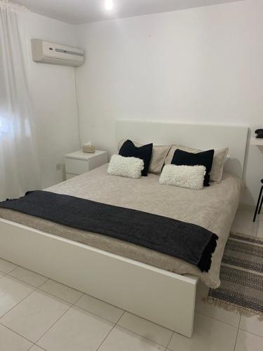 a bed with two pillows on it in a room at STS 21, Nicosia-Lakatamia one-bedroom Apartment in Kato Lakatamia