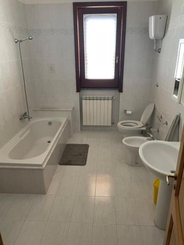 y baño con bañera, aseo y lavamanos. en Casa Leonardo, en Monteroni di Lecce