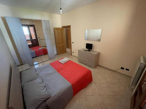 1 dormitorio con 1 cama con manta roja en Casa Leonardo, en Monteroni di Lecce