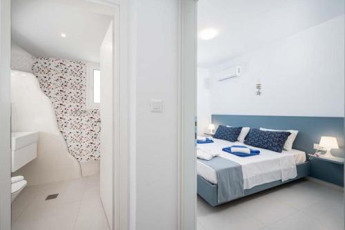 a bedroom with a bed with blue and white furniture at Xenos Villa 7 with a Private pool near the sea in Tigaki