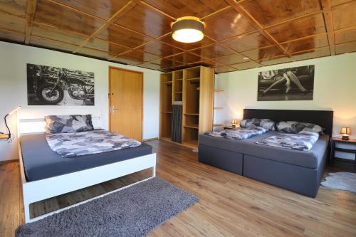 two beds in a room with wooden ceilings at Hus8 Krumbach in Krumbach