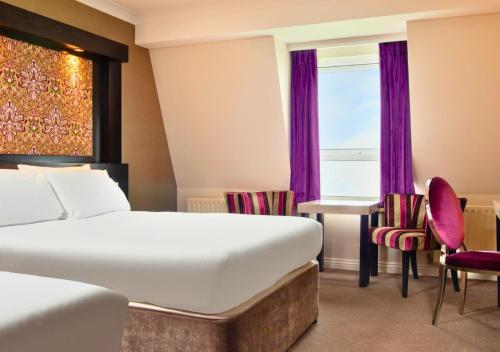 a hotel room with a bed and a desk and a window at Flannery's Hotel in Galway