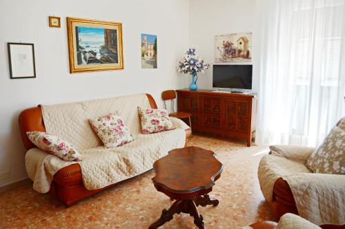 uma sala de estar com um sofá e uma mesa em La Piazza - appartamento em Piana Battolla
