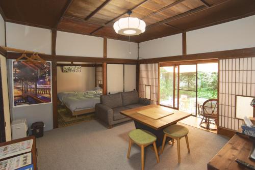 een woonkamer met een bank en een tafel bij AI/藍 in Kusatsu