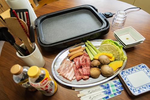 a table with a plate of food and a suitcase at AI/藍 in Kusatsu