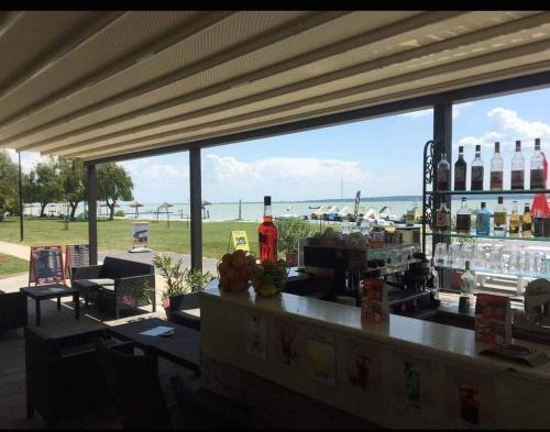 un bar con vistas al océano desde la playa en Babzsi Nyaraló, en Vonyarcvashegy
