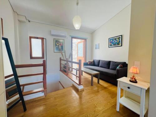 a living room with a couch and a stair case at House of light in Évdhilos