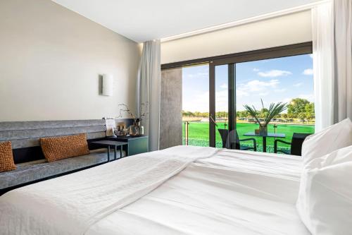 um quarto com uma grande cama branca e uma grande janela em Ringenäs Hotell & Konferens em Halmstad