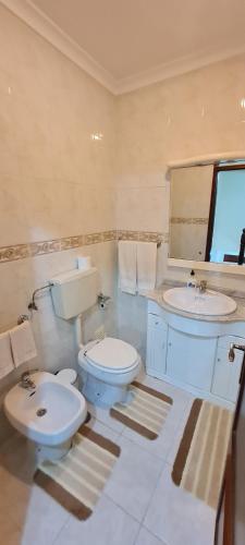 a white bathroom with a toilet and a sink at Lovely Modern Duplex 3 Bedroom Flat in Quiet Area in Tavarede