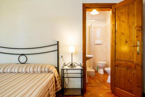 a bedroom with a bed and a bathroom with a toilet at Margherita - Agriturismo La Fattoria in Grosseto