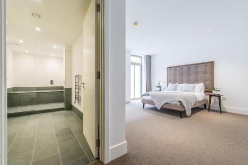 a bedroom with a bed and a bath room with a tub at Stunning apartment building, walking distance to Ealing Broadway tube! in Ealing