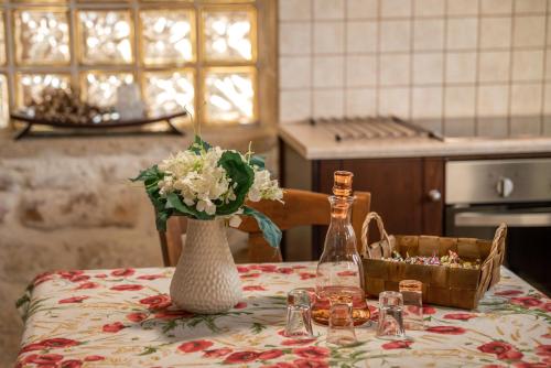a table in a kitchen with a vase of flowers on it at The Stonemade Houses in Falasarna