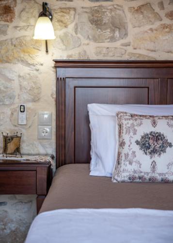 a bedroom with a bed with a stone wall at The Stonemade Houses in Falasarna