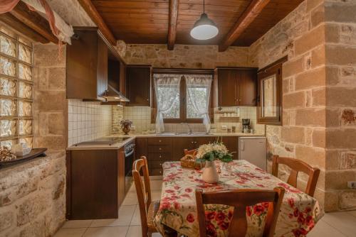 a kitchen with a table and chairs in a room at The Stonemade Houses in Falasarna