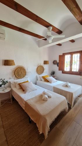 a bedroom with two beds and a ceiling at Casa Playa Javea in Jávea