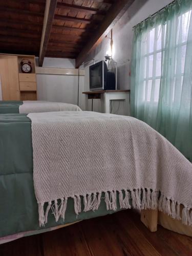 a bedroom with a bed with a white blanket on it at Casa Centrica con garage in Mercedes