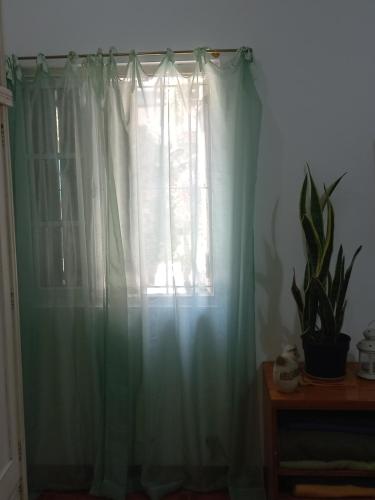 a window with white curtains in a room at Casa Centrica con garage in Mercedes