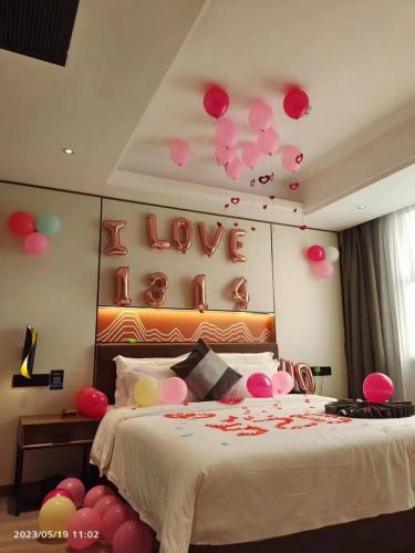 ein Schlafzimmer mit einem Bett mit Ballons an der Wand in der Unterkunft Elong Leisure Hotel, Hengyang Fenghuang Road County Government in Shaoyang County
