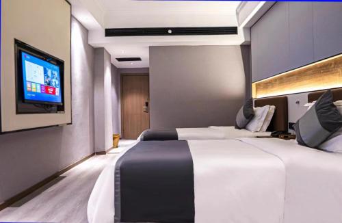 ein Hotelzimmer mit 2 Betten und einem Flachbild-TV in der Unterkunft Elong Leisure Hotel, Hengyang Fenghuang Road County Government in Shaoyang County