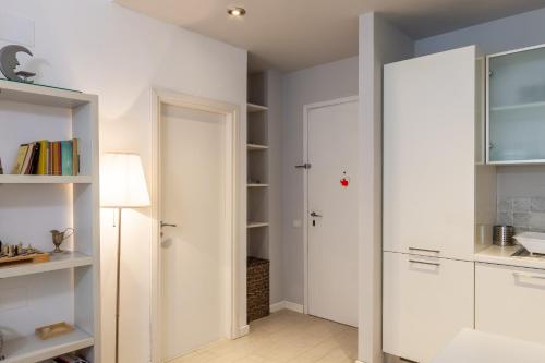 een kamer met witte kasten en een kast met een deur bij La Casa nel parco in Viareggio