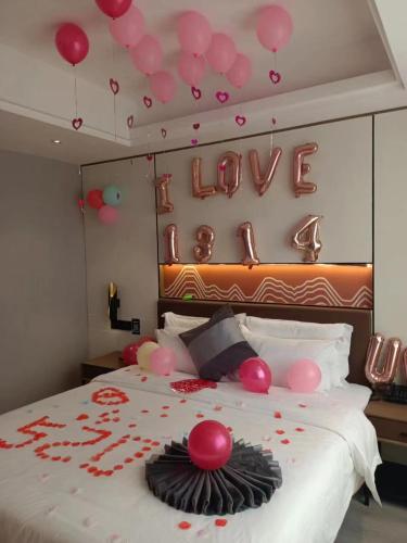 a bedroom with a bed with a sign that reads love at Elong Leisure Hotel, Hengyang Fenghuang Road County Government in Shaoyang County