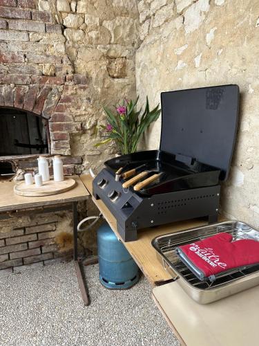 - un barbecue assis sur une table à côté d'une cheminée dans l'établissement La Gravonne, une parenthèse turroise, à Turny