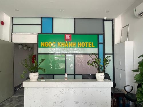 a sign for a koreakin hotel with two potted plants at Ngoc Khanh hotel in Nha Trang