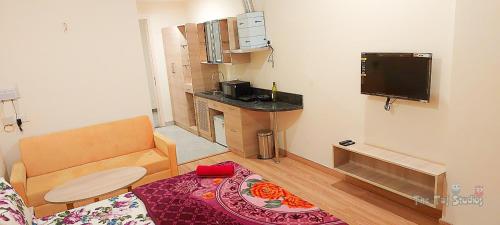 una pequeña sala de estar con sofá y TV en Top Luxuries Couple Friendly Stay in Gaur Mall by Taj Studios, en Ghaziabad