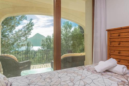 a bedroom with a bed and a balcony with a view at Can Mir Sa Posada des Pagès in Formentor