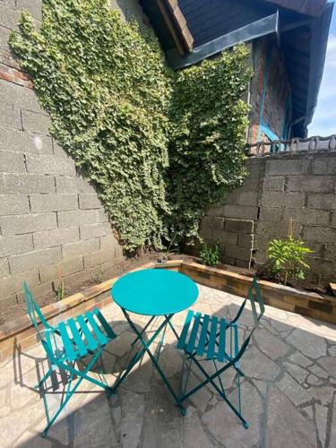 une table et deux chaises assises à côté d'un mur de briques dans l'établissement La Symphorine, à Grandvilliers